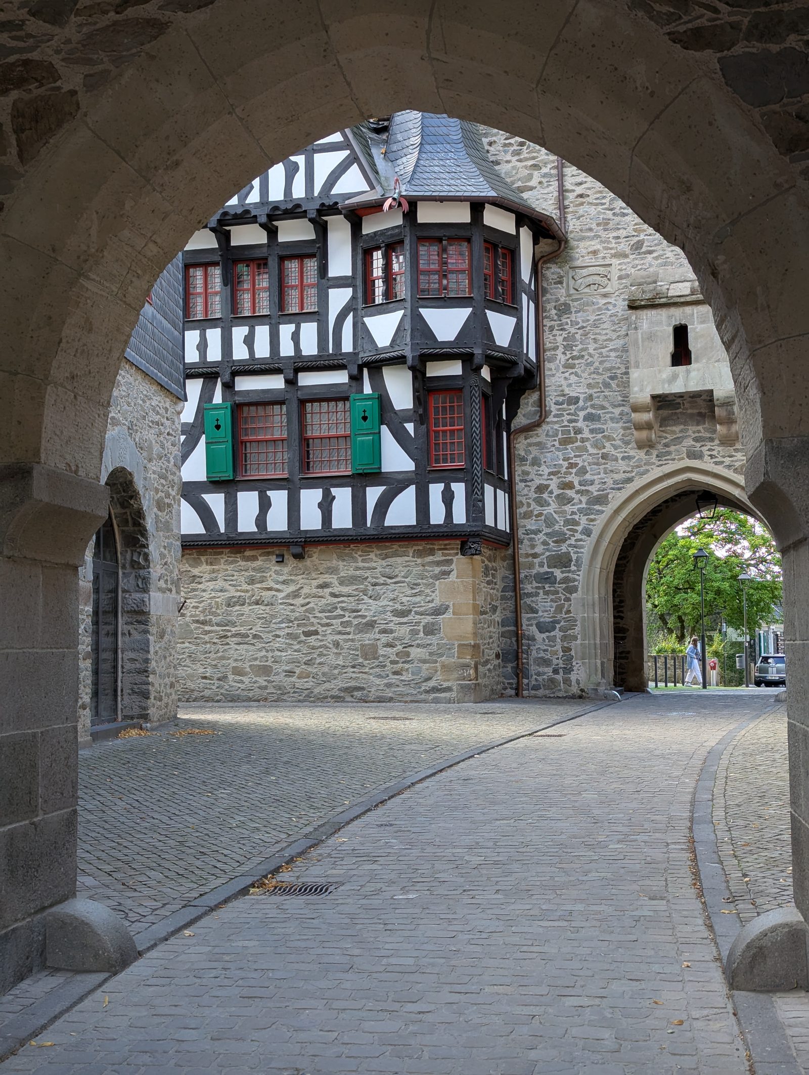 Blick durch ein Tor von Schloss Burg auf Fachwerk und Bruchstein